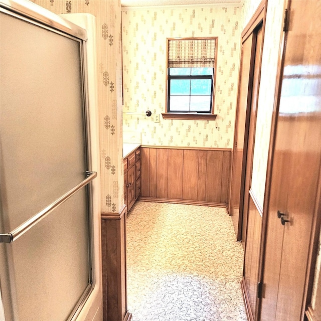 hall featuring light colored carpet and wooden walls