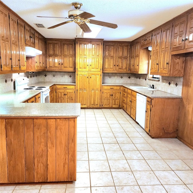 kitchen with kitchen peninsula, decorative backsplash, white appliances, and light tile patterned floors