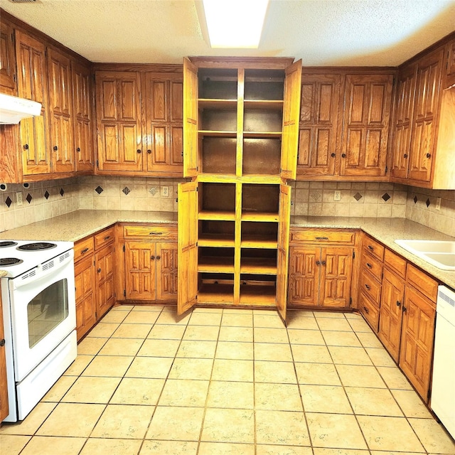 kitchen with sink, white appliances, backsplash, and light tile patterned floors