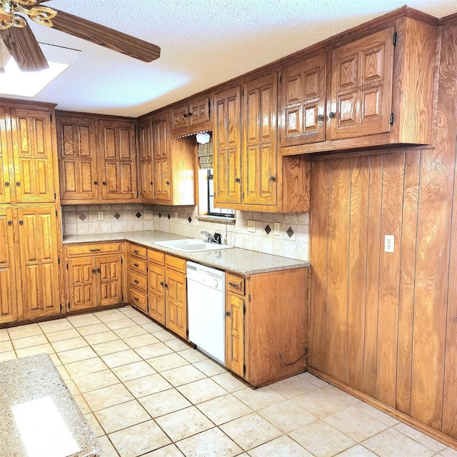 kitchen featuring backsplash, ceiling fan, sink, and white dishwasher