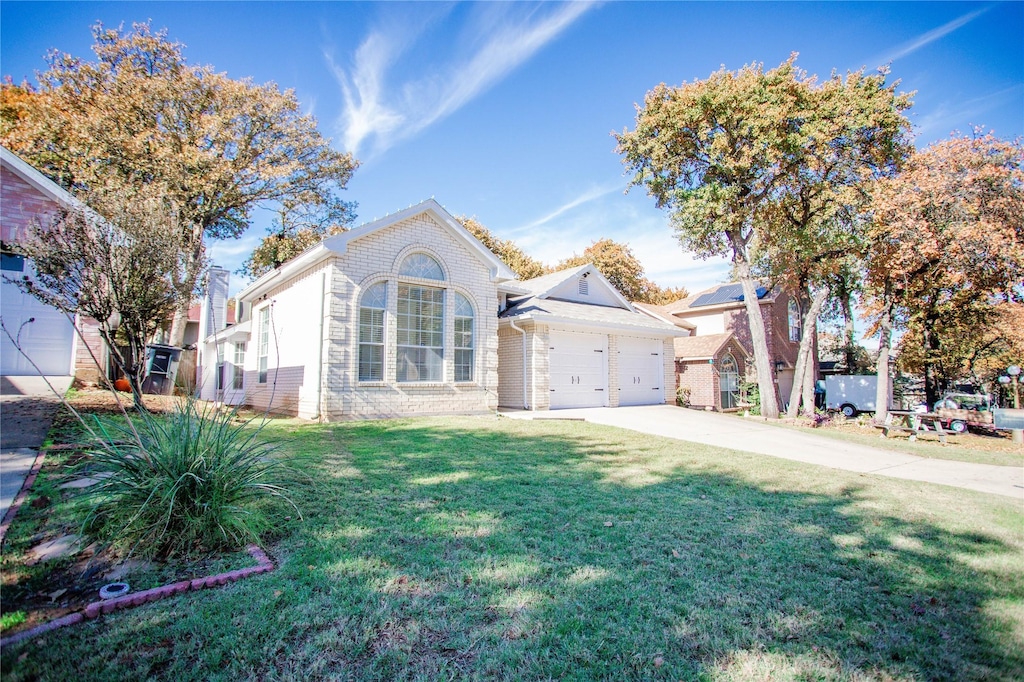 view of front of property featuring a front lawn and a garage