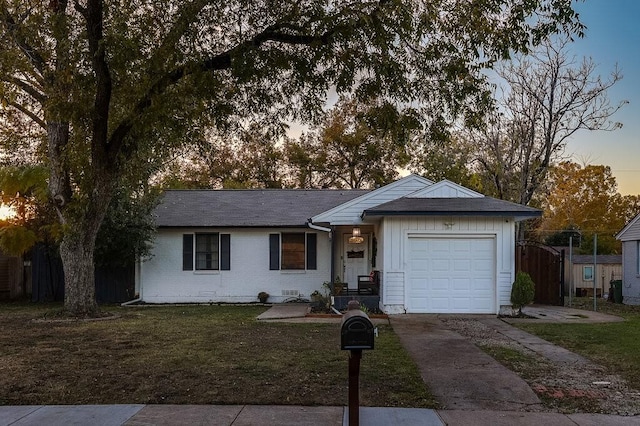 ranch-style house featuring a yard and a garage