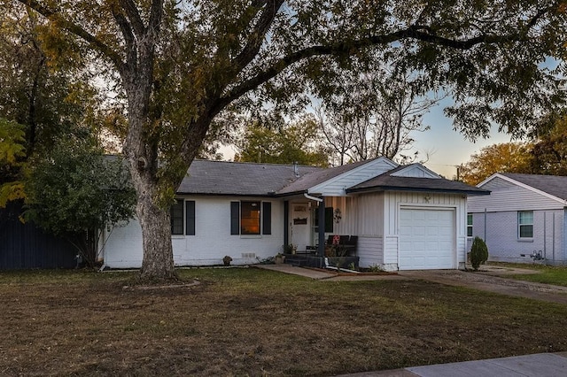 ranch-style house with a garage and a yard