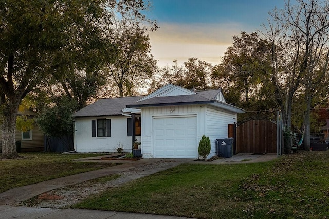 single story home with a garage and a lawn