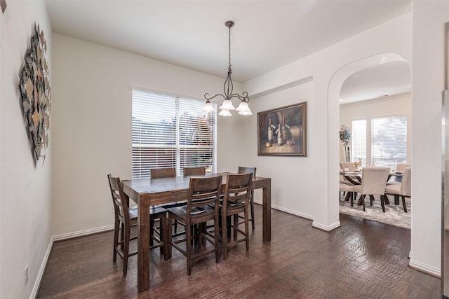 dining area with a chandelier and dark wood-type flooring