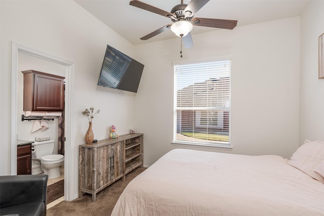 bedroom featuring dark colored carpet, connected bathroom, and ceiling fan