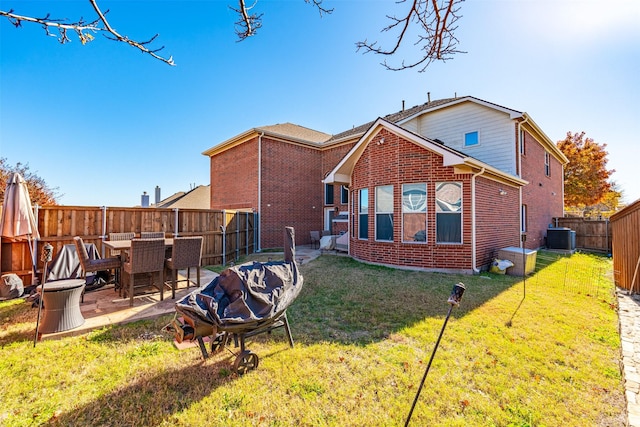 rear view of property with central AC unit, a patio area, and a lawn