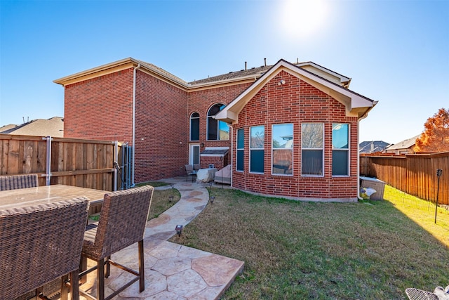 back of house with a lawn and a patio area