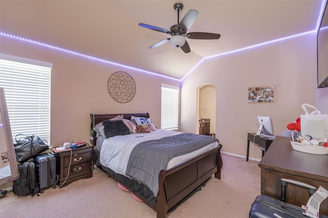 carpeted bedroom with multiple windows, ceiling fan, and vaulted ceiling