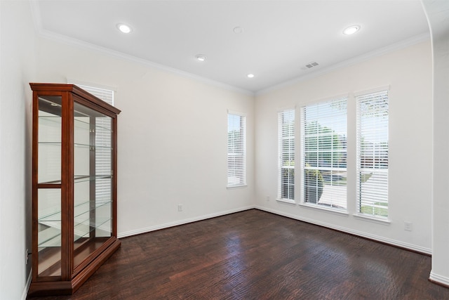 spare room featuring ornamental molding, visible vents, baseboards, and dark wood-type flooring