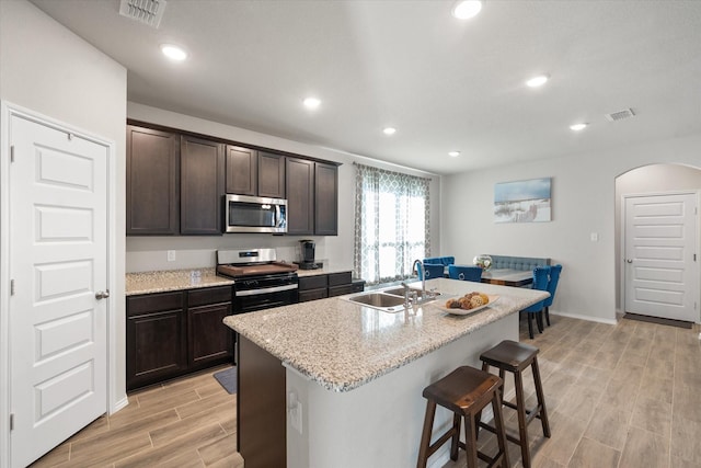 kitchen with visible vents, appliances with stainless steel finishes, arched walkways, and a sink