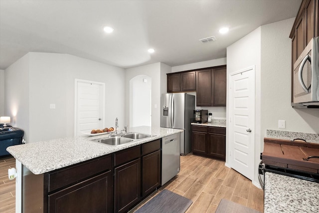 kitchen with wood finish floors, stainless steel appliances, visible vents, a sink, and dark brown cabinetry