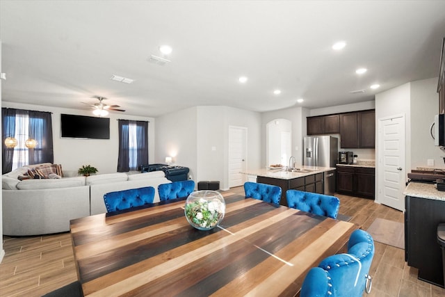 dining room featuring arched walkways, recessed lighting, a ceiling fan, visible vents, and wood tiled floor