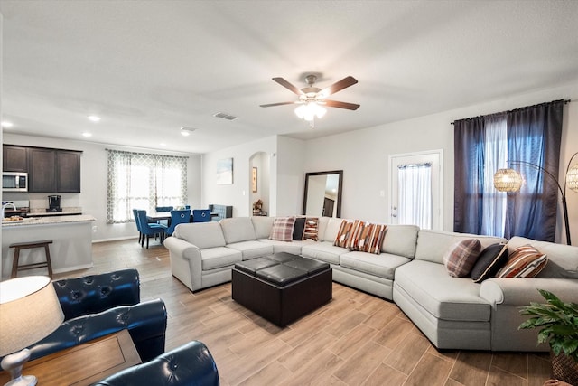 living area with visible vents, arched walkways, a ceiling fan, wood finish floors, and recessed lighting