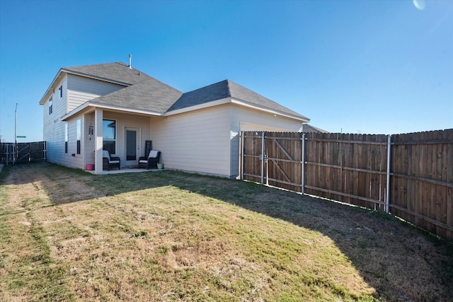 rear view of house featuring a yard, a patio area, and a fenced backyard