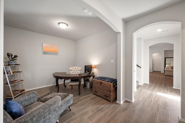 office area with wood finish floors, visible vents, and baseboards