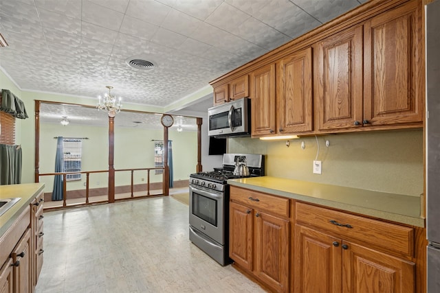 kitchen featuring appliances with stainless steel finishes, a notable chandelier, and decorative light fixtures