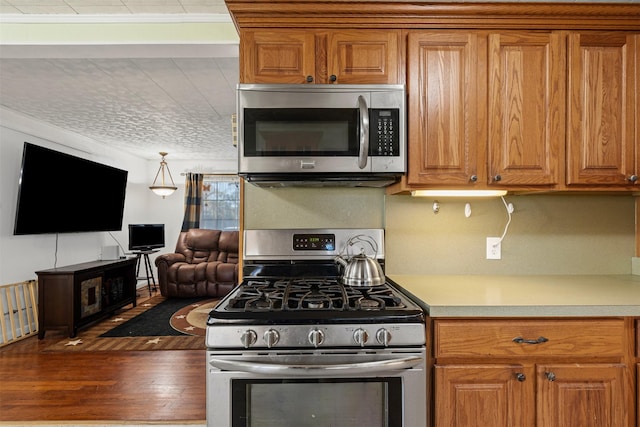 kitchen with appliances with stainless steel finishes and hardwood / wood-style floors