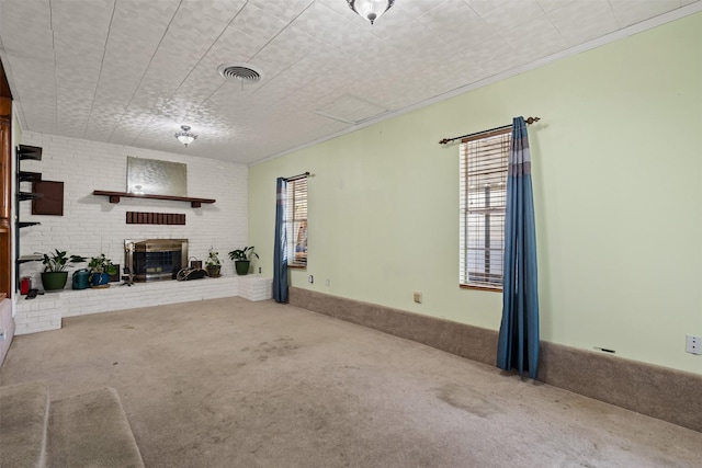 unfurnished living room featuring a brick fireplace and carpet flooring