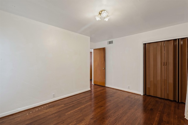 unfurnished bedroom featuring dark wood-type flooring and a closet