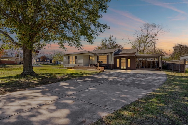 ranch-style home featuring a carport and a yard