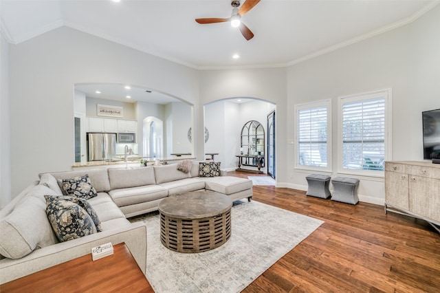 living room with hardwood / wood-style floors, ceiling fan, and crown molding