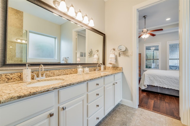 bathroom with wood-type flooring, vanity, ceiling fan, and ornamental molding