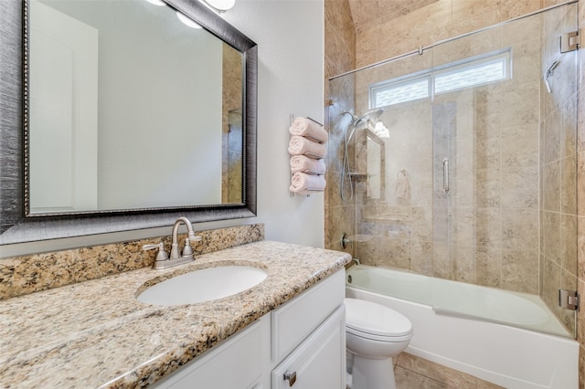 full bathroom with tile patterned flooring, tiled shower / bath combo, toilet, and vanity