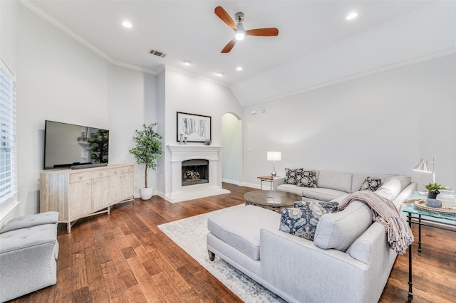 living room featuring hardwood / wood-style floors, ceiling fan, lofted ceiling, and crown molding