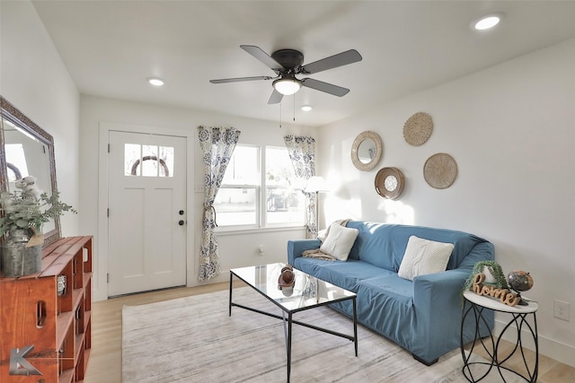 living room with light hardwood / wood-style flooring and ceiling fan