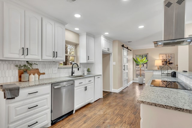 kitchen with sink, island range hood, white cabinets, stainless steel dishwasher, and a barn door