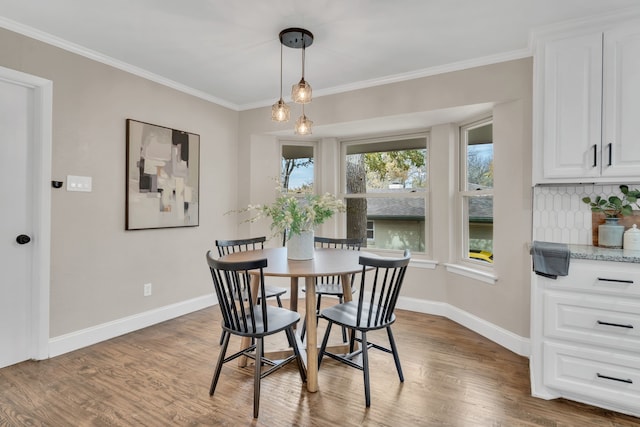 dining space featuring hardwood / wood-style floors and crown molding