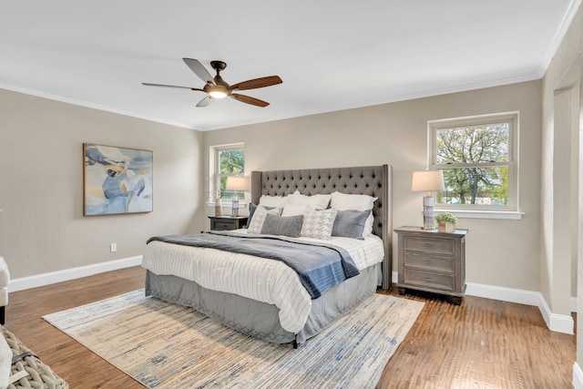 bedroom featuring light hardwood / wood-style flooring, multiple windows, crown molding, and ceiling fan