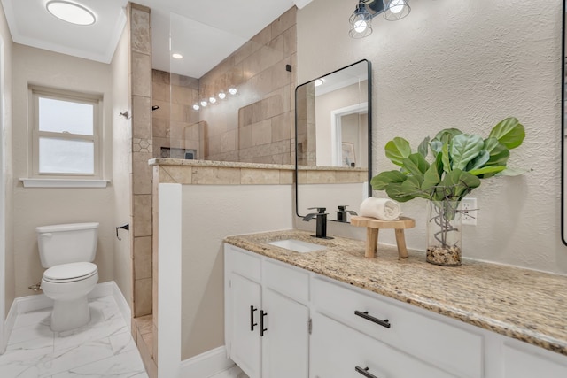 bathroom featuring crown molding, toilet, tiled shower, and vanity