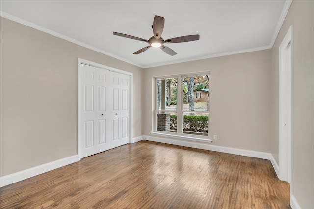 unfurnished bedroom with wood-type flooring, a closet, ceiling fan, and crown molding