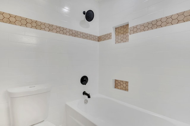 bathroom with tiled shower / bath combo and toilet