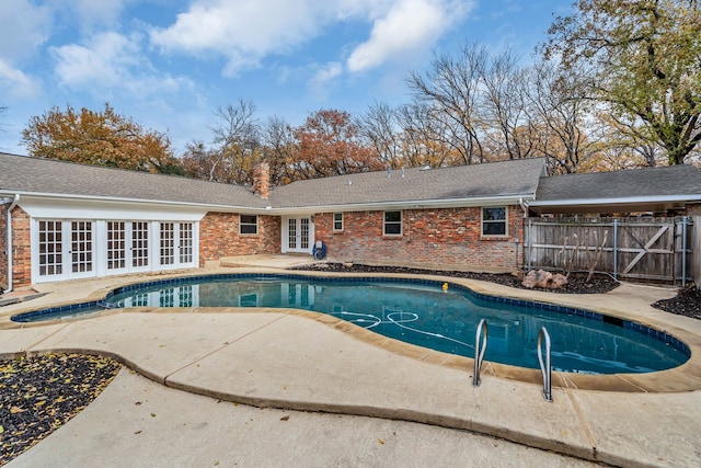 view of swimming pool featuring a patio area and french doors