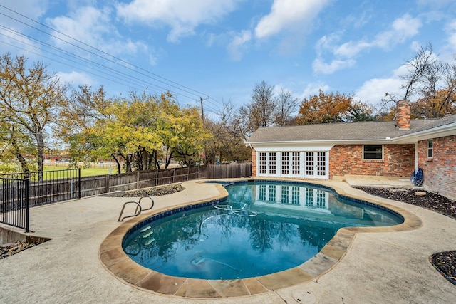 view of swimming pool featuring a patio and french doors