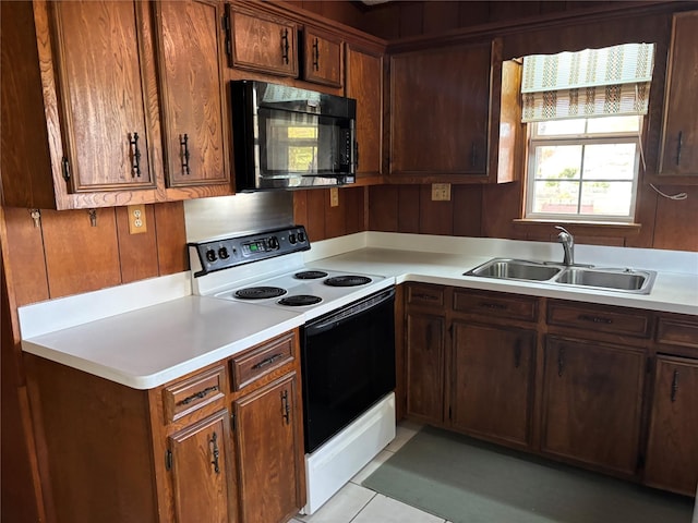 kitchen with light tile patterned floors, sink, and electric stove