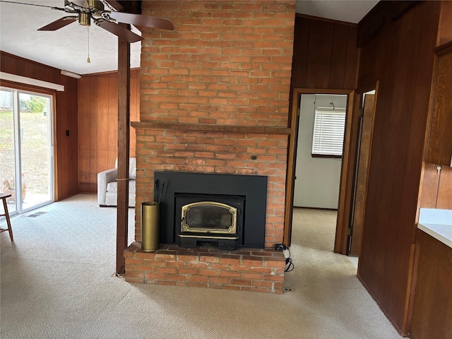 carpeted living room with wood walls and ceiling fan