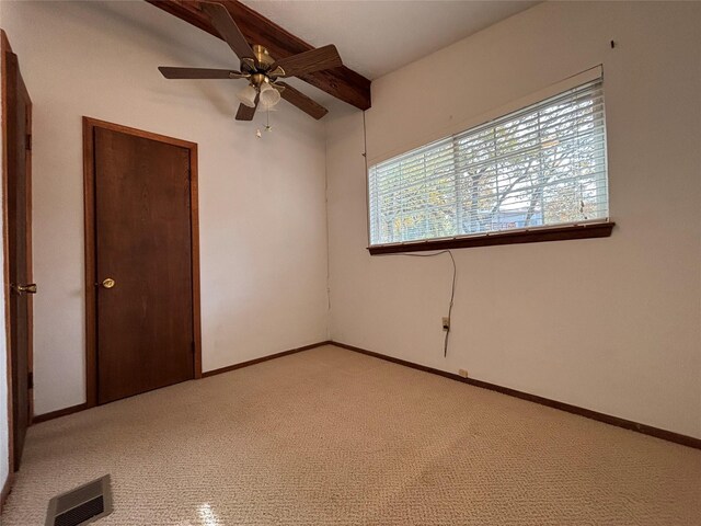 empty room with ceiling fan and light carpet