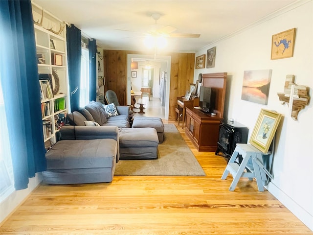 living room featuring light hardwood / wood-style floors, ceiling fan, and ornamental molding