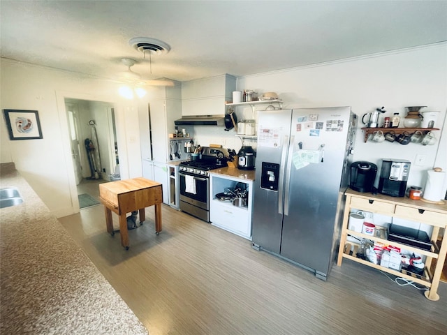 kitchen with appliances with stainless steel finishes, dark wood-type flooring, sink, exhaust hood, and white cabinets