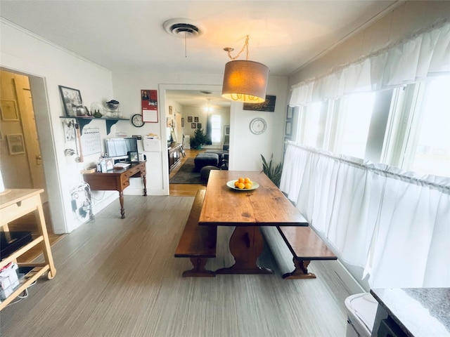 dining space featuring ornamental molding and hardwood / wood-style flooring