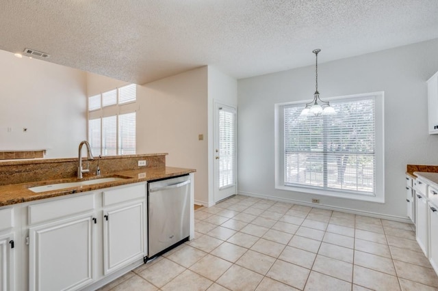 kitchen with dark stone countertops, white cabinetry, and stainless steel dishwasher