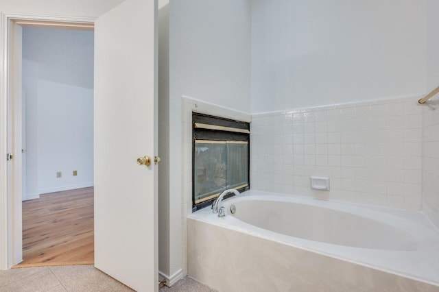 bathroom with wood-type flooring and a tub