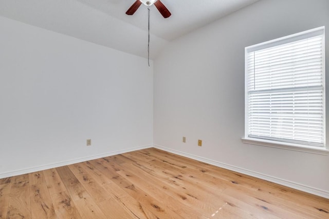 spare room featuring lofted ceiling, ceiling fan, light wood-type flooring, and a wealth of natural light