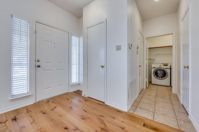 entryway with a wealth of natural light, light hardwood / wood-style floors, and washer / clothes dryer