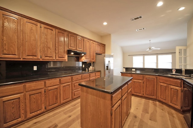 kitchen featuring sink, black appliances, light hardwood / wood-style floors, and a kitchen island