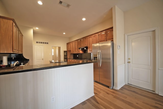 kitchen featuring stainless steel fridge with ice dispenser, kitchen peninsula, and light hardwood / wood-style flooring